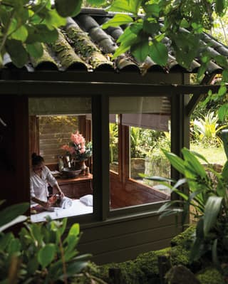 View through a window of a spa therapist preparing a massage table