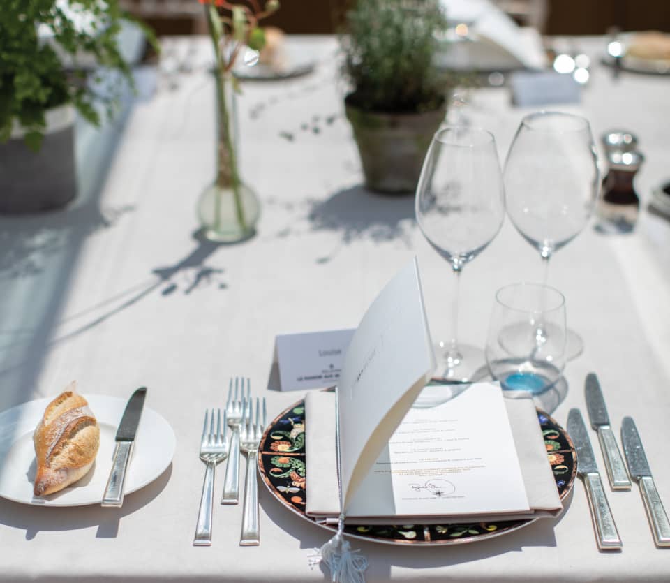 Elegant menu card at a place setting on top of a flower patterned dish