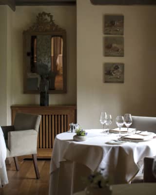 Circular table set with silverware and glasses in a room filled with natural light