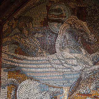 A mosaic in tiny tiles of blue and white depicts Greek God Perseus riding the winged horse, Pegasus, across golden skies