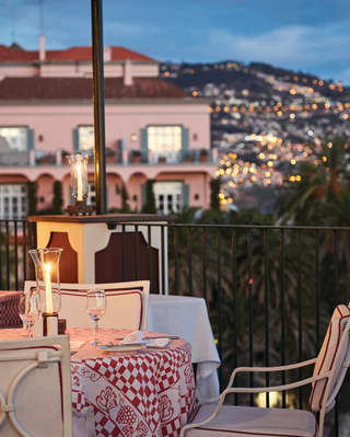 Close-up of a formal candlelit table for two with a red and white checked tablecloth