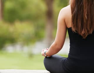Lady in a lotus yoga pose in the gardens of Belmond Rio Sagrado