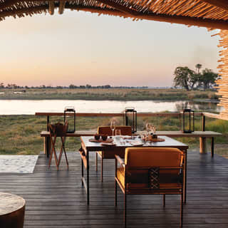 Shaded veranda with an elegant seating area and views across grasslands at sunset