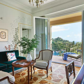 Elegant hotel suite with mid-century Italian furniture and a parquet floor