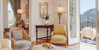 Hotel suite lounge with floor-to-ceiling glass balcony doors and canary yellow furniture