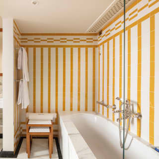 Carrara marble bath and sink under terracotta striped tiles in a luxurious bathroom