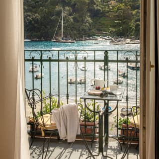 Hotel suite terrace with breakfast table, overlooking Portofino Bay
