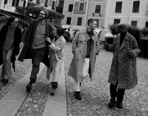 black and white image of four people walking down the Portofino harbar