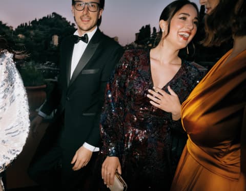 Four elegantly dressed guests laughing and celebrating