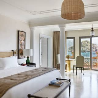 Light and airy hotel suite with vast pillowy bed and polished tile floors