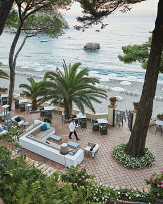 Aerial view of a barman walking across a clay tiled bar terrace