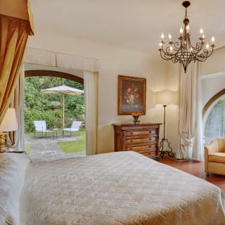 Spacious hotel room with a large arched window and lemon yellow accents