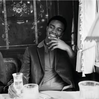 Two guests laughing in conversation and drinking champagne at a formal dining table