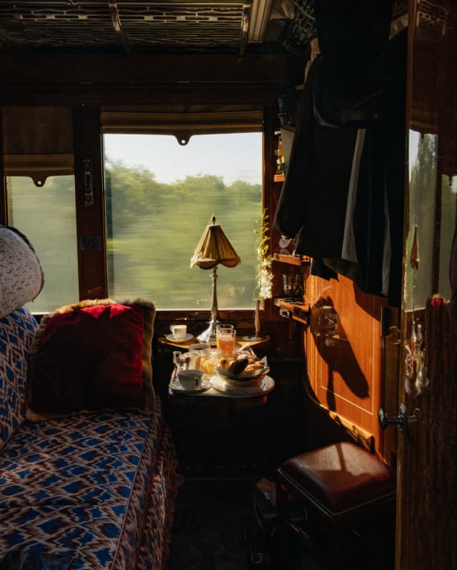 A wood cabin with upholstered banquette and a table of refreshments offers a luxury environment for watching the world go by.